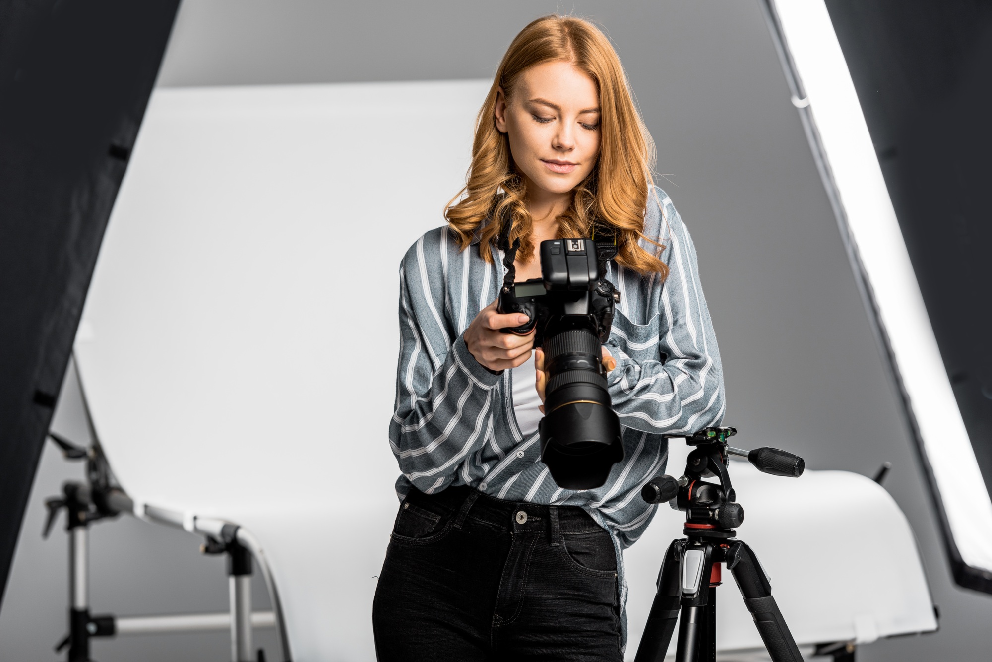 beautiful young woman using photo camera in studio